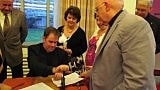 As  his family watches on, Thomas C. Gibbons presses the seal that makes official his lifetime contract with the Paulist Father. Mr. Gibbons get an assist from Father Paul Huesing, Paulist formation director (right). (Photo credit: Bruce Byers, brucebyers.com)