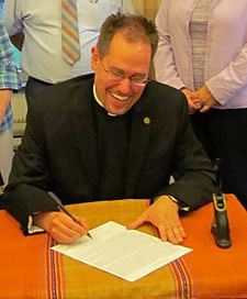 Richard R. Andre, CSP, signs his lifetime contract with the Pauist Fathers Sept. 2 at St. Paul's College as his family watches on.
