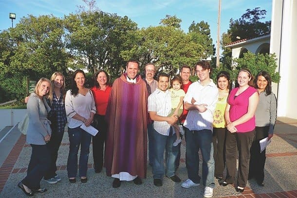 Father Dave Dwyer, CSP, with young adults after Mass.