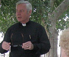 Father Paul G. Robichaud, CSP (standing) gives the pilgrims an introduction to Caprnaum, the "Town of Jesus" where he often preached. 