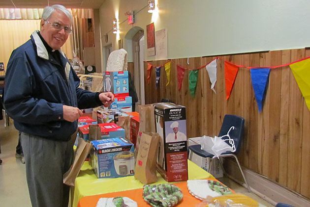 Father Steven Bossi, CSP, drops in his ticket to win one of the numerous raffle prizes available at the Fall Fair of St. Peter's Church, Toronto.