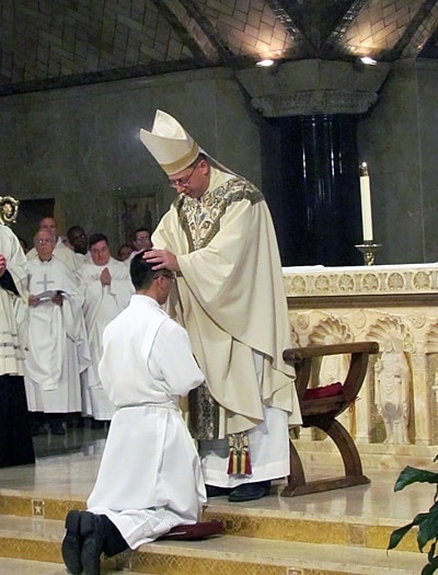 Bishop Barry C. Knestout of Washington, D.C., lays hands on Pauist Jimmy Hsu.