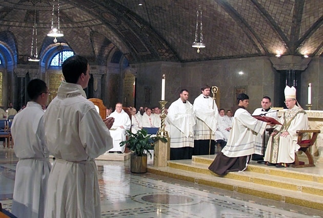 Auxiliary Bishop Barry C. Knestout of Washington, D.C., examines the candidates for the diaconate during a Sept. 7 Mass in the Crypt Church of the Shrine of the Immaculate Conception in Washington, D.C. Paulist Jimmy Hsu stands to the far left.
