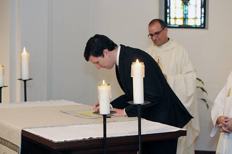 Paolo Puccini, CSP signs the book that lists him as a member of the community after he made his first promise with the Paulists.