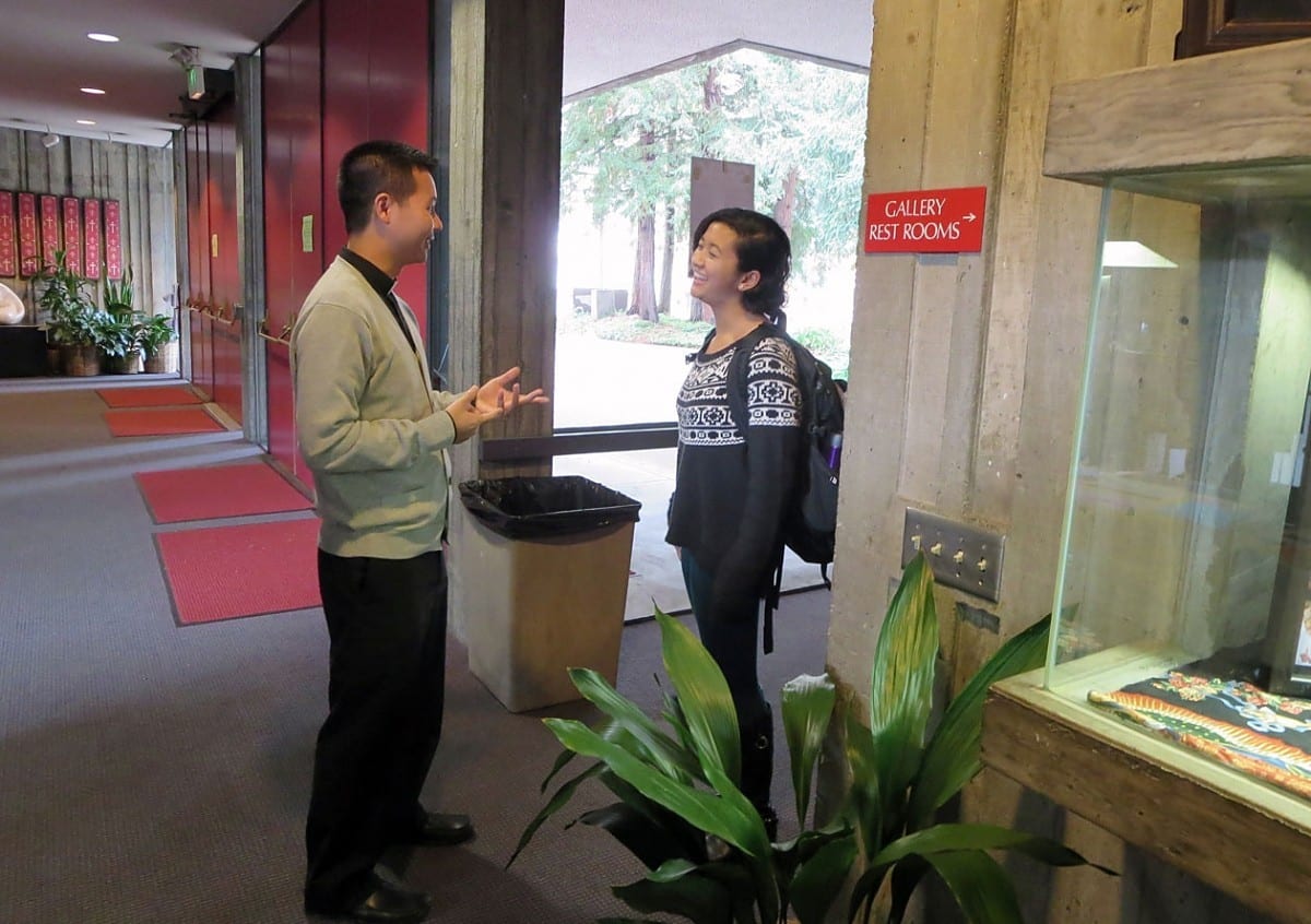 Father Dat Tran, CSP, stops to speak with a Berkeley student in the lobby of Newman Hall-Holy Spirit Parish at the University of California at Berkeley.