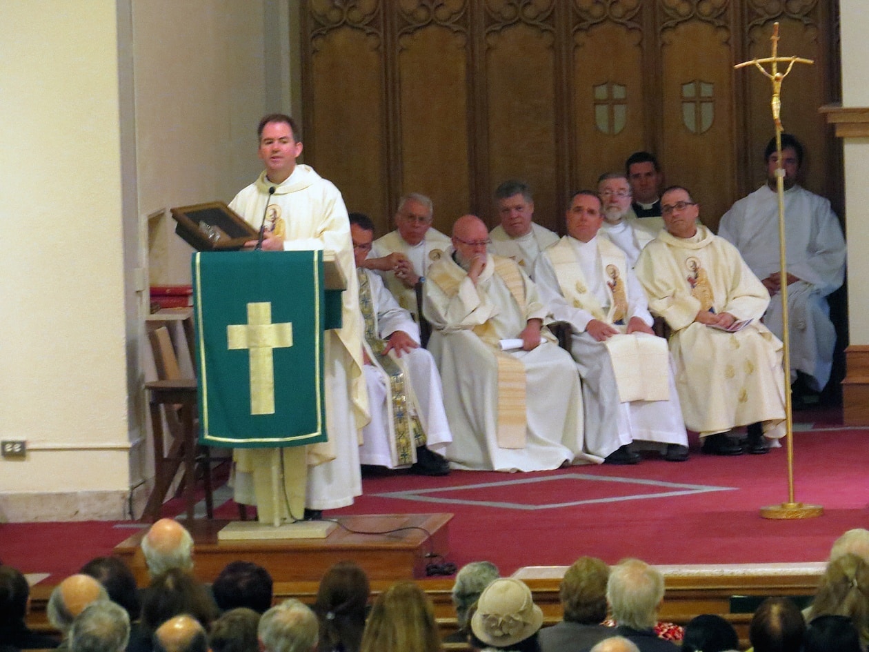 Father Tom Gibbonds, administrator at St. Peter’s, presents a framed plaque of the founder of the Paulist Fathers, Servant of God Father Isaac T. Hecker, to St. Peter’s as a testemant to the 102 years the Paulists have served the parish.