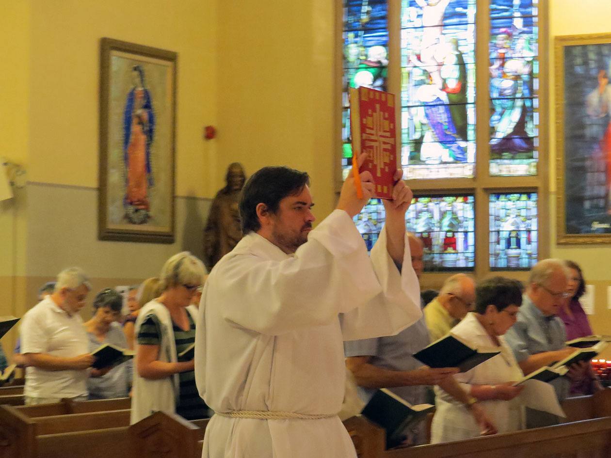 Stuart Wilson-Smith, CSP, a Paulist student from Fredericton, New Brunswick, processes into the Mass carrying the Book of Gospels.