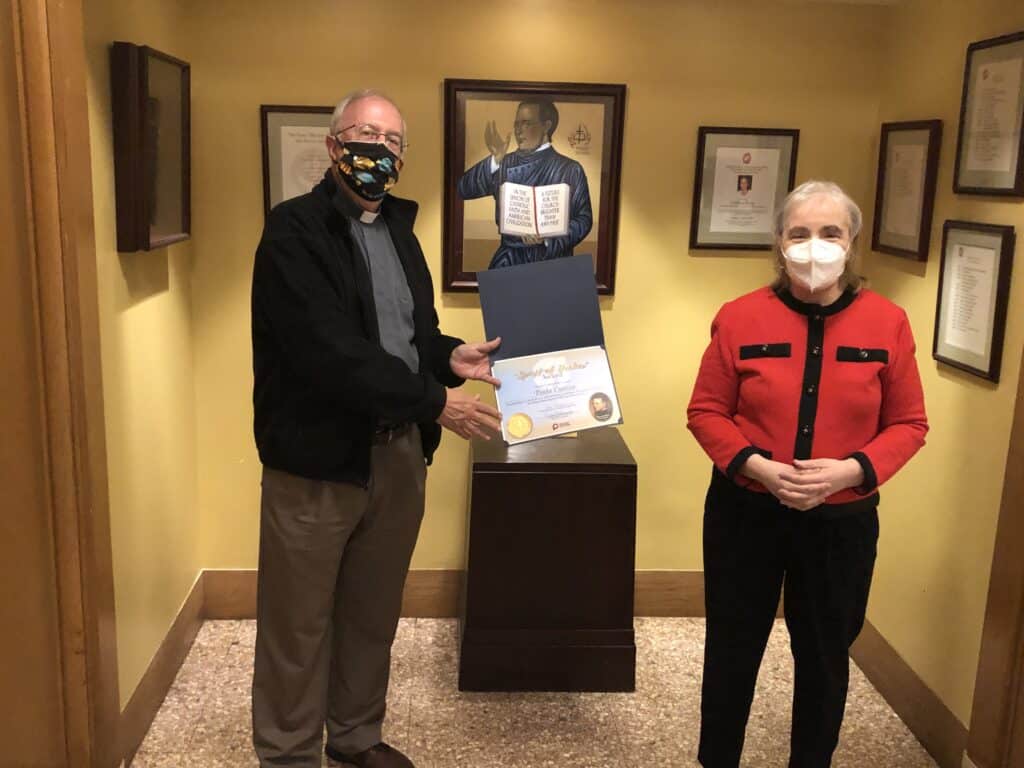 Fr. Micahel McGarry, CSP, Director of Paulist Center Boston, presents a “Spirit of Hecker” Award to Associate (and Associates World Founding Editor) Paula Cuozzo.