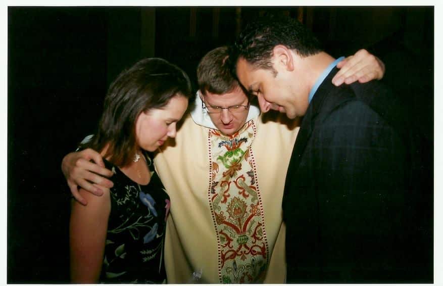 Fr. Charlie prays with a couple, May 2005